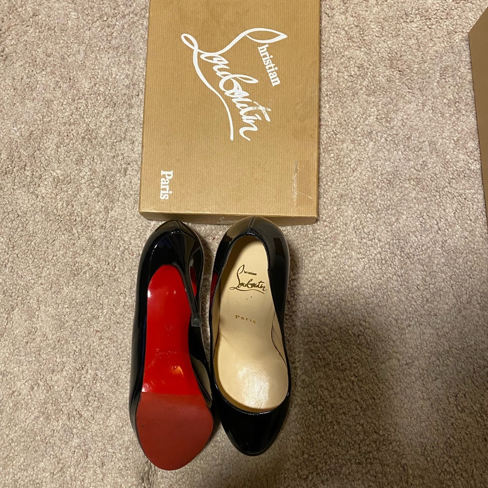 Christian Louboutin‘s black heel gently worn red bottom still intact